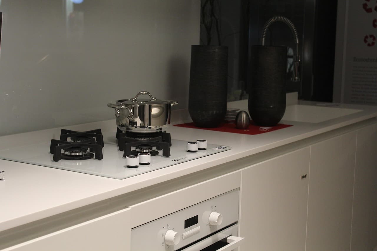 A gas hob lit on a white worktop in a newly finished kitchen