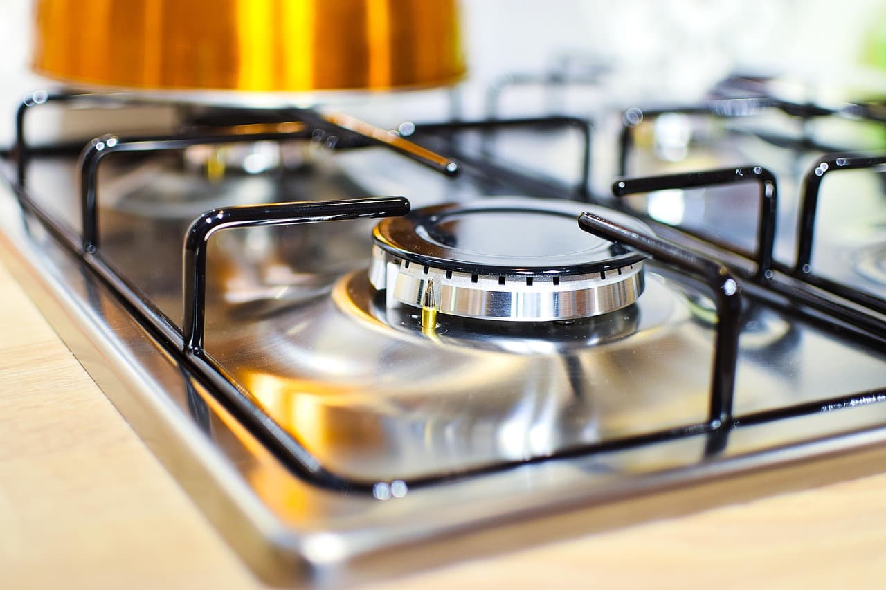 A stainless gas hob set into a wooden worktop